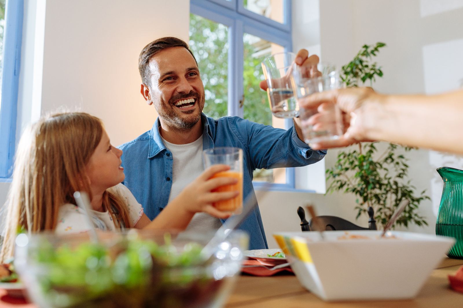 Family toasting glasses of clean drinking water at home in the Triangle